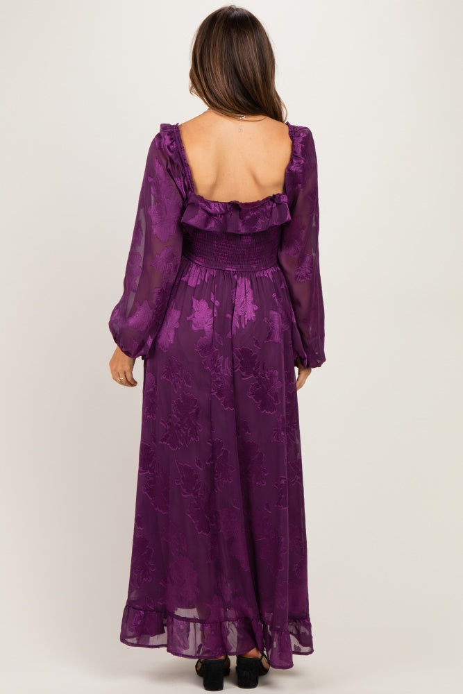 woman wearing a purple floral maxi maternity dress with long sleeves and a smocked waist, showing a baby bump