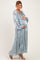 woman wearing a light blue floral maternity maxi dress and holding her baby bump