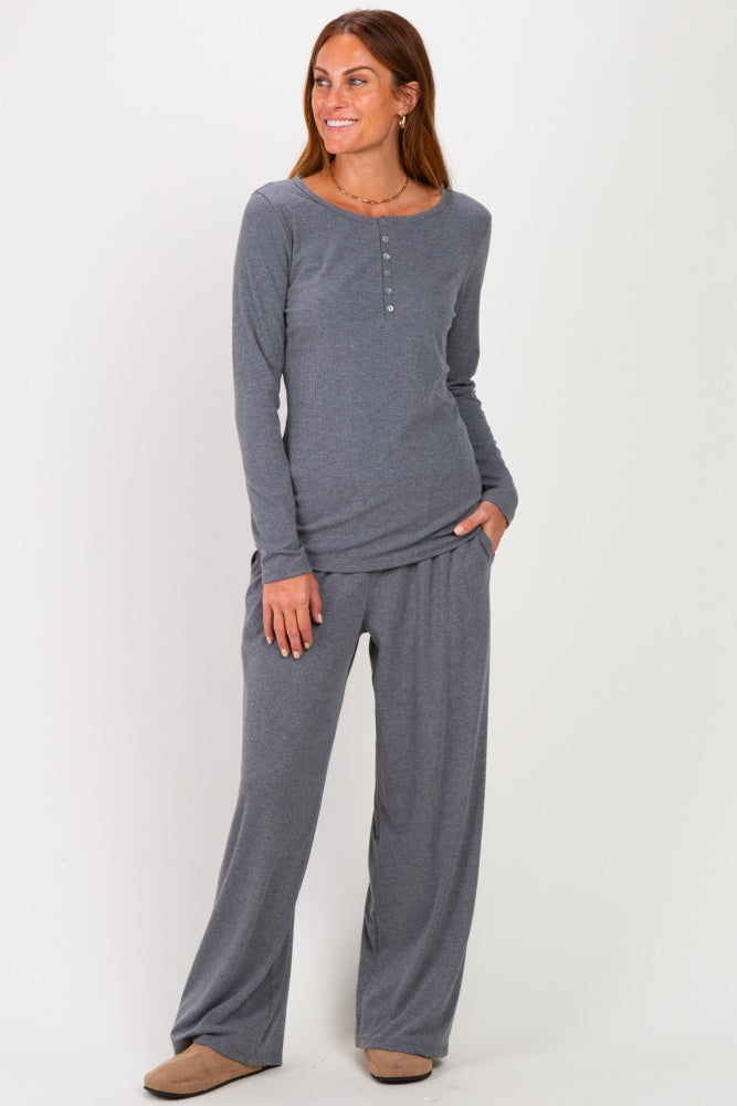 woman wearing a gray long sleeve henley top and matching wide-leg pants, posing with one hand in her pocket