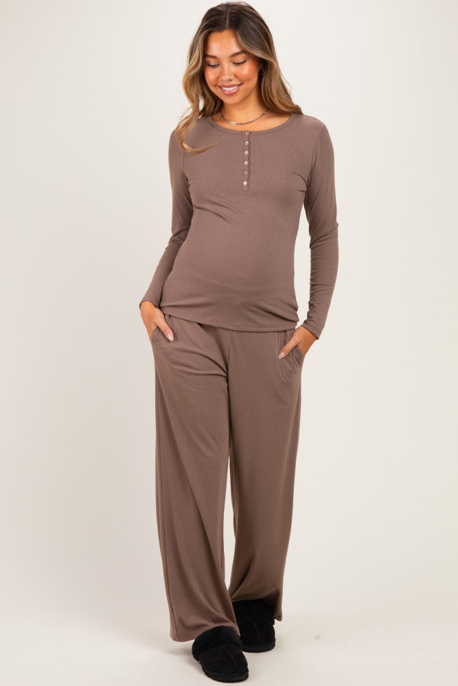 woman wearing a brown long sleeve maternity top with buttons and matching wide-leg pants, showing her baby bump