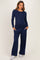 woman wearing a navy blue long sleeve maternity top with buttons and matching loose-fit maternity pants, hands in pockets