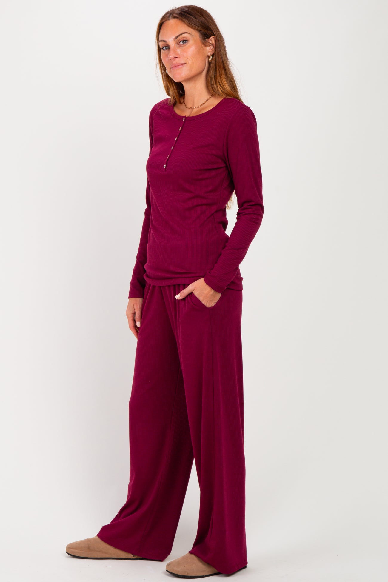 woman wearing a burgundy long sleeve top with button detail and matching wide-leg pants