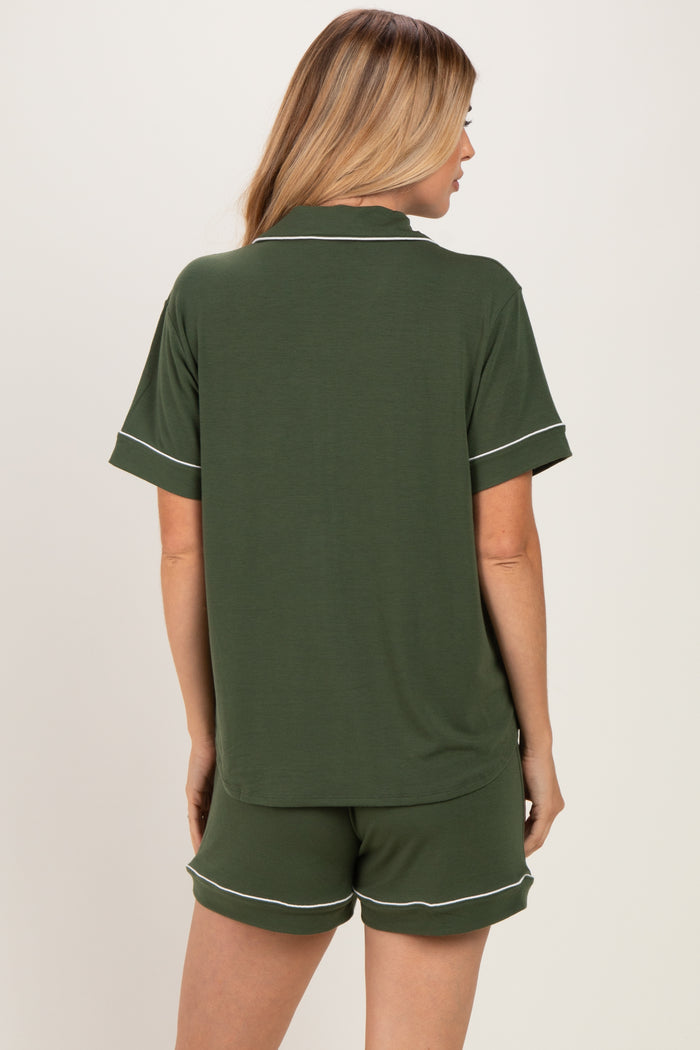 woman wearing a green short sleeve top with white trim and matching shorts, viewed from the back