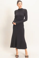 woman wearing a black long sleeve ribbed knit midi dress with a fitted bodice and flared skirt