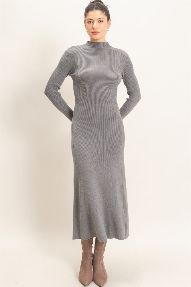 woman wearing a form-fitting gray ribbed knit midi dress with long sleeves and a high neckline