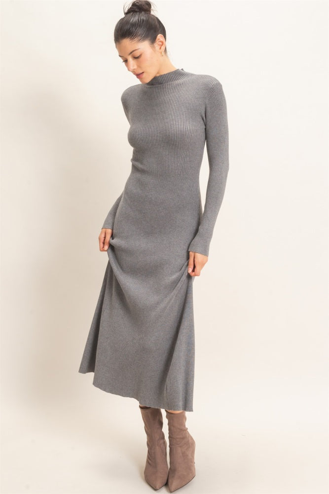 woman wearing a fitted gray ribbed maxi dress with long sleeves and a high neckline, paired with taupe ankle boots