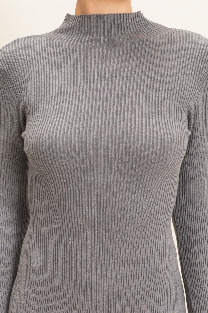 woman wearing a gray ribbed long sleeve top with a high neck design