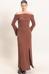woman wearing a brown off-the-shoulder ribbed maxi dress with long sleeves and a side slit