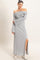 woman wearing a light gray off-the-shoulder ribbed maxi dress with long sleeves and a side slit