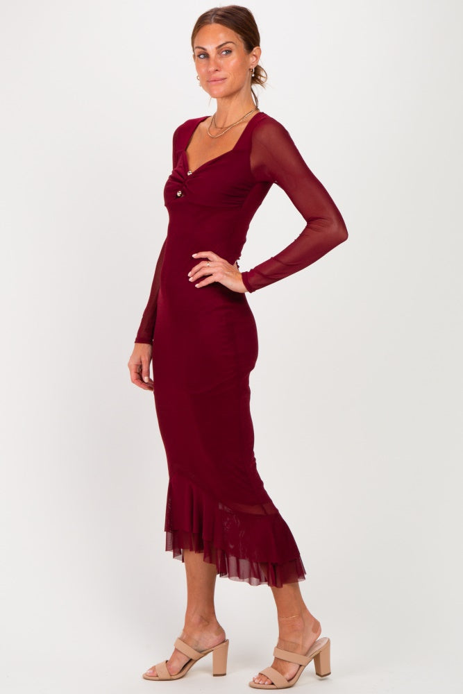 woman wearing a burgundy long sleeve dress with a flounced hem and a sweetheart neckline