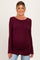 woman wearing a burgundy long sleeve maternity top and showing her baby bump