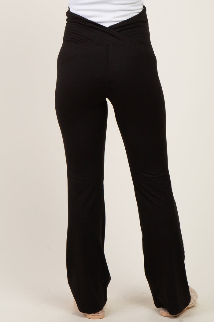woman wearing black maternity yoga pants with a crossover waistband, view from the back
