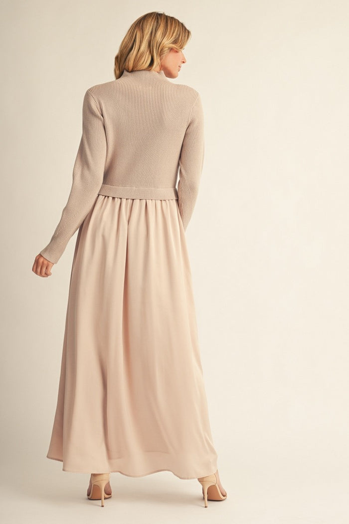 woman wearing a beige long sleeve knitted sweater with a flowy light pink maxi skirt