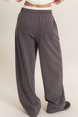 woman wearing gray wide-leg pants with an elastic waistband and back pocket