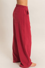woman wearing loose-fitting maroon wide-leg pants with side pockets