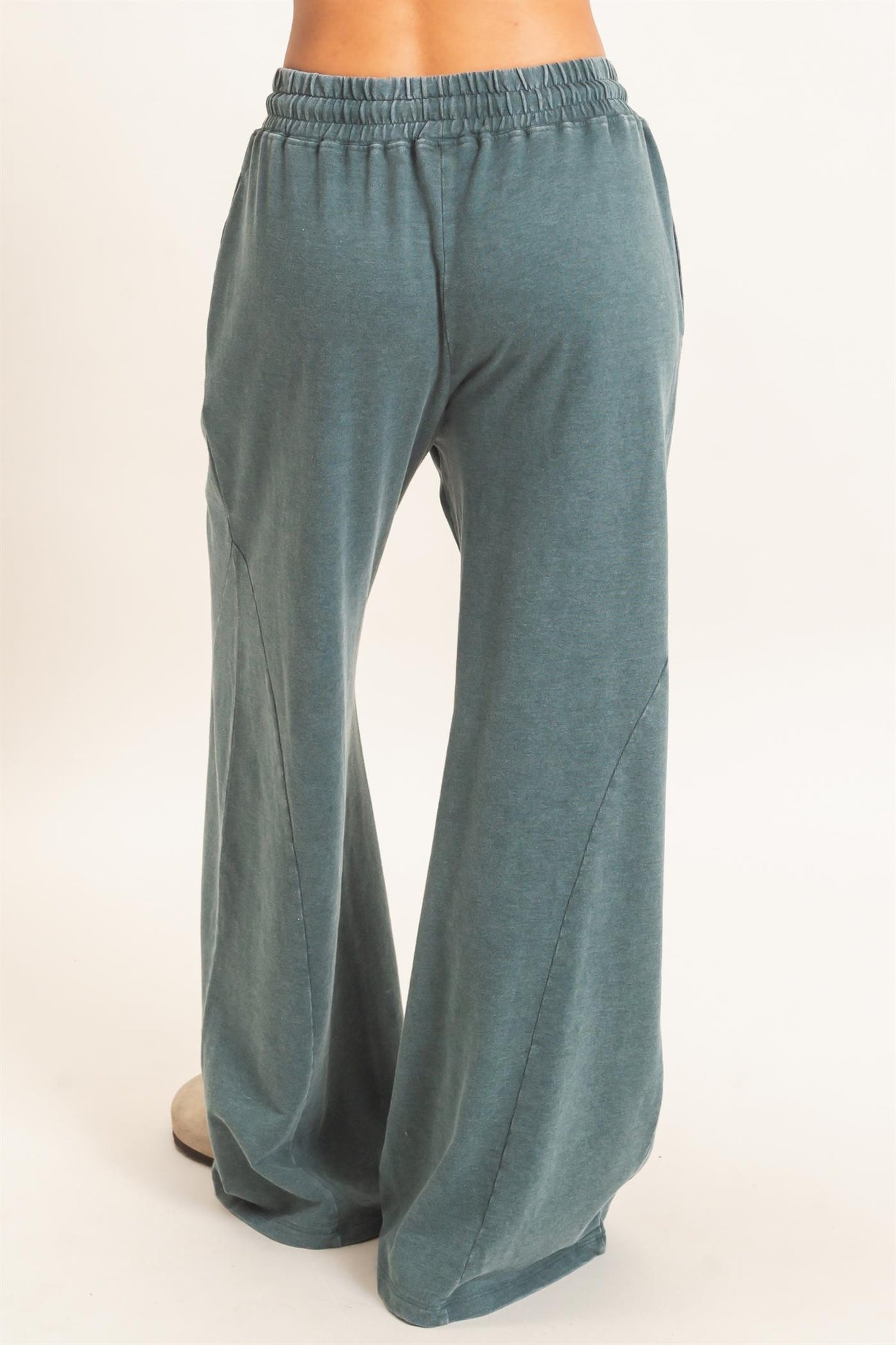 woman wearing teal wide-leg lounge pants showing back view with elastic waistband and side pockets