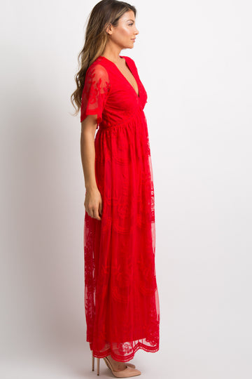 woman wearing a red midi dress with a floral pattern, walking away in a scenic outdoor setting