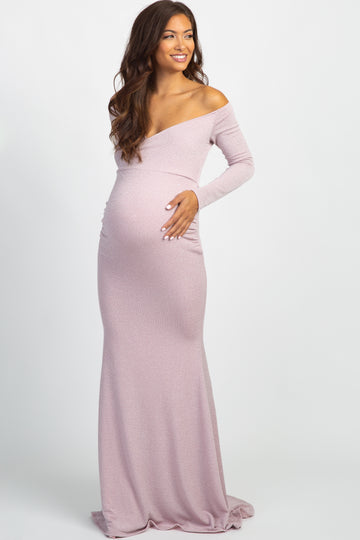 woman wearing a light pink sparkly maternity dress and holding her baby bump at a baby shower celebration