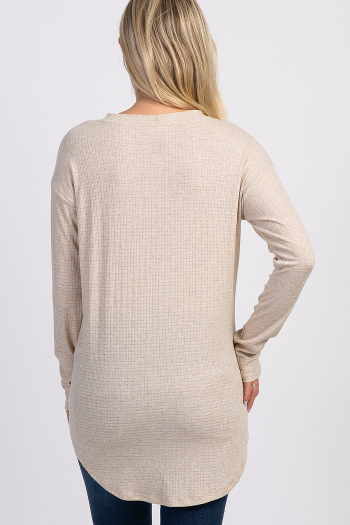 woman wearing a beige long sleeve maternity top with a textured finish, visible from the back