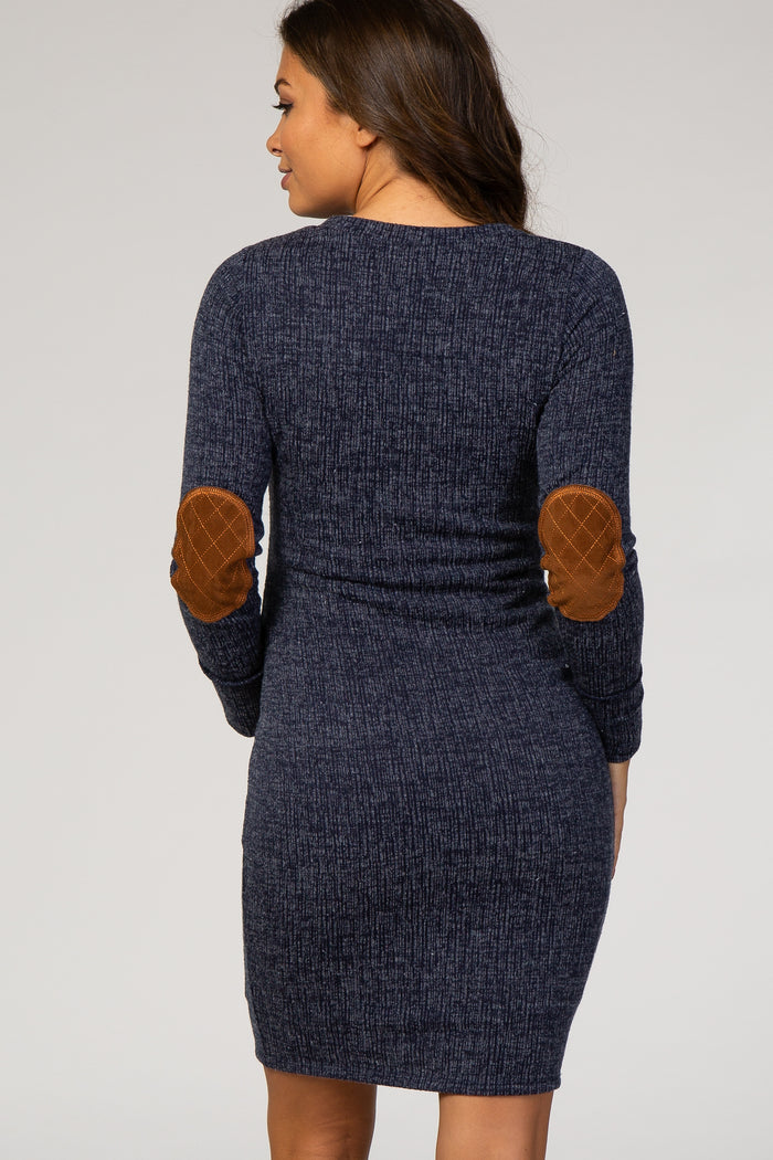 woman wearing a navy blue knitted maternity dress with long sleeves and tan elbow patches, showing the back view