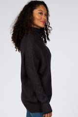 woman wearing a dark gray oversized turtleneck sweater with a relaxed fit and curly hair