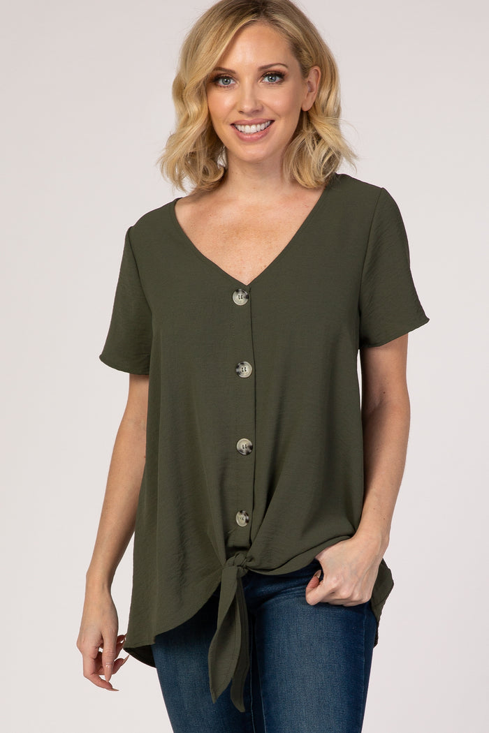 woman wearing an olive green short sleeve button down top with a front tie hem and blue jeans