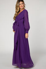 woman wearing a purple long sleeve maternity dress with a wrap style and tie waist, showcasing her baby bump