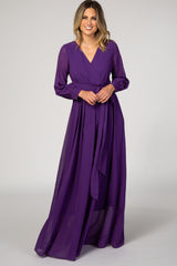 woman wearing a purple long sleeve wrap maxi dress with a tie waist and a flowy skirt