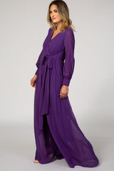 woman wearing a long purple wrap dress with billowy sleeves and a tie waist detail