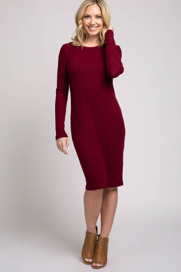 woman wearing a burgundy long sleeve fitted dress and tan heeled ankle boots