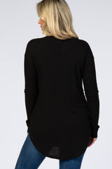 woman wearing a black long sleeve maternity top with a curved hem and a relaxed fit, viewed from the back