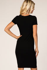woman wearing a fitted black short sleeve dress, showing the back view