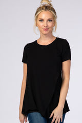 woman wearing a black short sleeve top with a flowy hem and paired with blue jeans