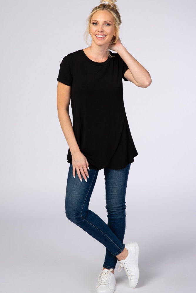 woman wearing a black short sleeve top paired with blue skinny jeans and white sneakers