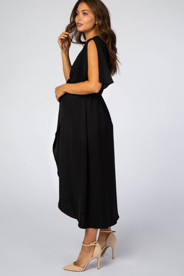 woman wearing a black maternity dress with short flutter sleeves and a flowing skirt, showing her baby bump
