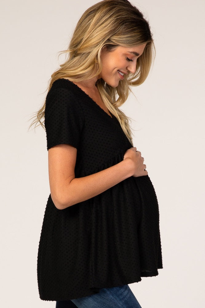 woman wearing a black short sleeve maternity top and holding her baby bump