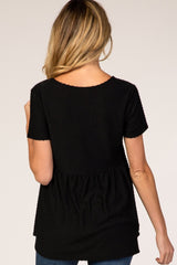 woman wearing a black short sleeve maternity top with textured detail and peplum style, showing the back view