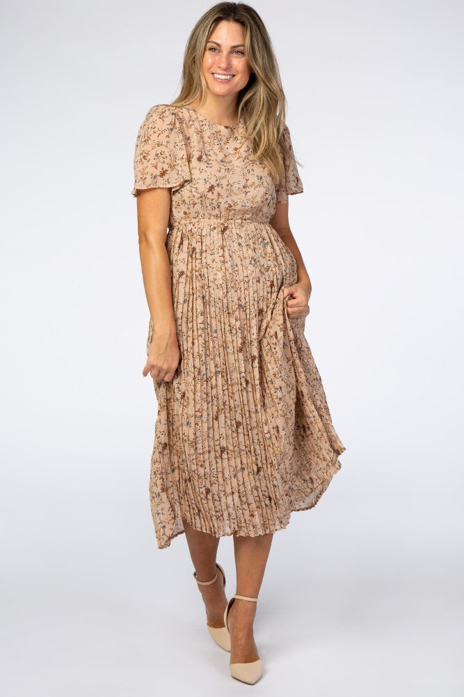 woman wearing a blush pink floral midi dress with short sleeves and pleated skirt