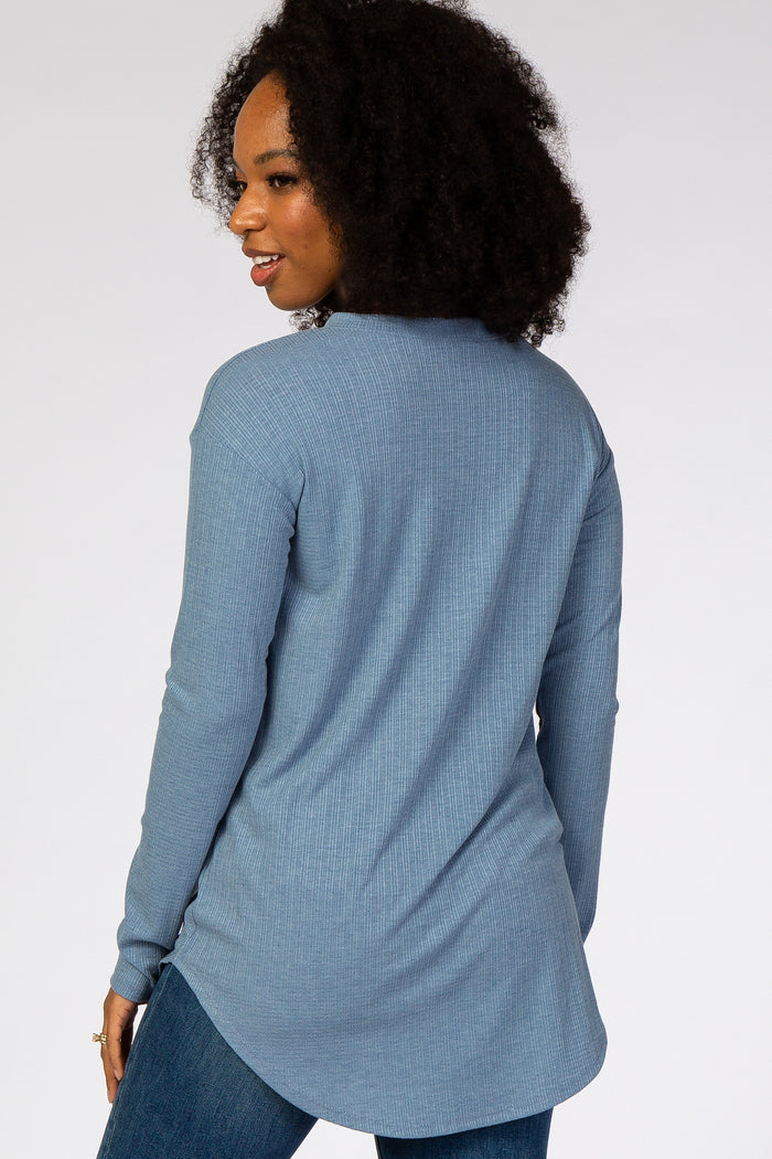 woman wearing a blue long sleeve ribbed knit tunic top from the back