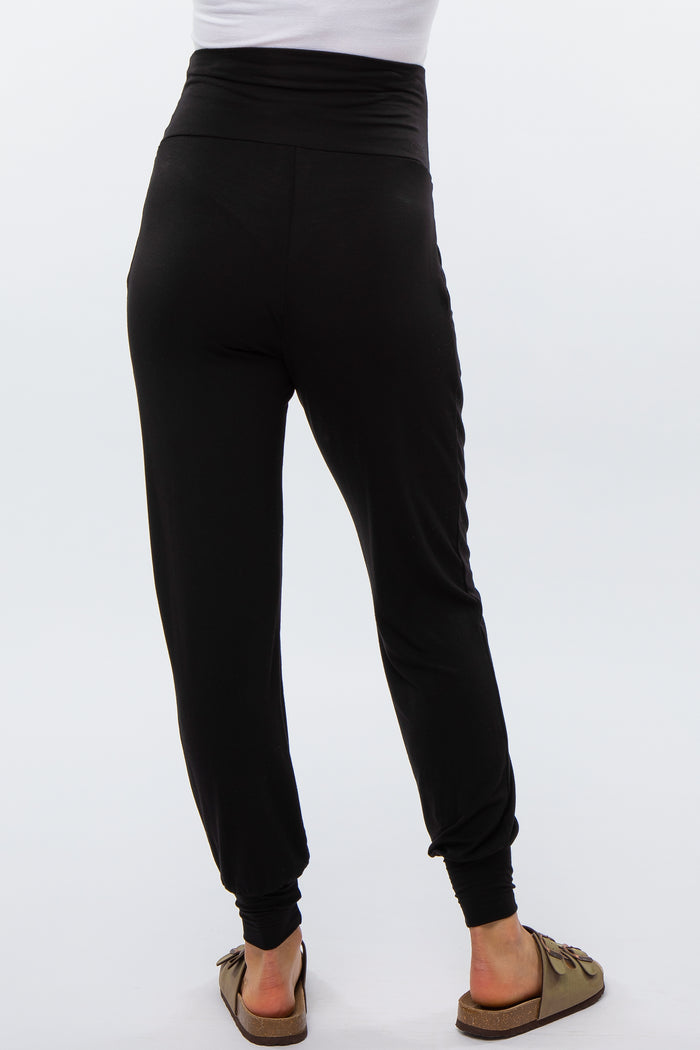 woman wearing black maternity joggers with a high waistband, viewed from the back