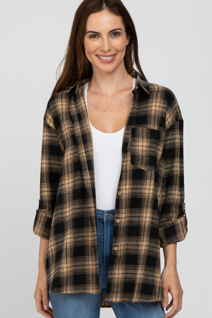 woman wearing a black and tan plaid flannel shirt over a white tank top with rolled-up sleeves and blue jeans