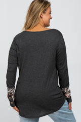 woman wearing a dark gray maternity plus top with leopard print detail on the sleeves and a relaxed fit