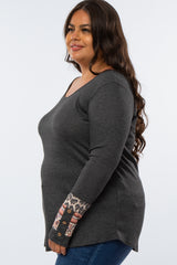woman wearing a dark gray long sleeve plus size top with patterned leopard and stripe detail on the sleeves