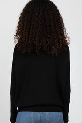 woman wearing a black oversized sweater, viewed from the back, paired with light blue jeans