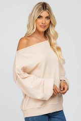 woman wearing a cream off-the-shoulder oversized sweater with long sleeves and relaxed fit