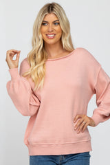 blonde woman wearing a light pink long sleeve knit sweater with balloon sleeves and a boat neckline