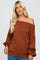 woman wearing a rust off-the-shoulder oversized sweater with balloon sleeves and a relaxed fit