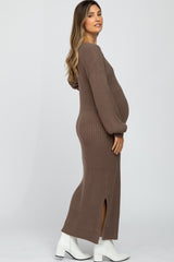 woman wearing a brown ribbed maternity dress with long sleeves and a side slit, showcasing her baby bump
