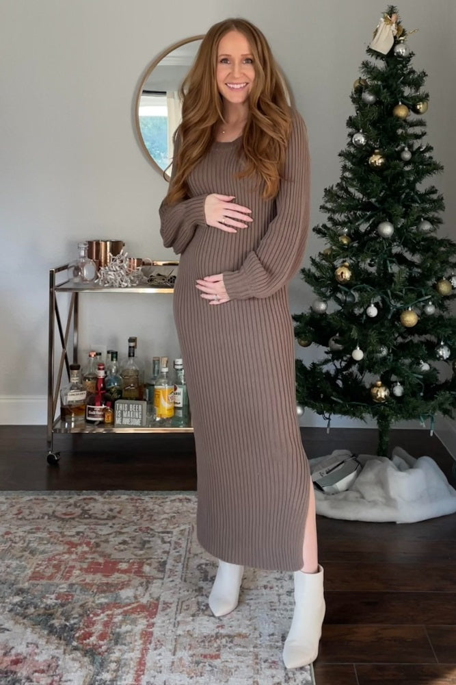 woman wearing a taupe ribbed maternity dress with side slits and holding her baby bump