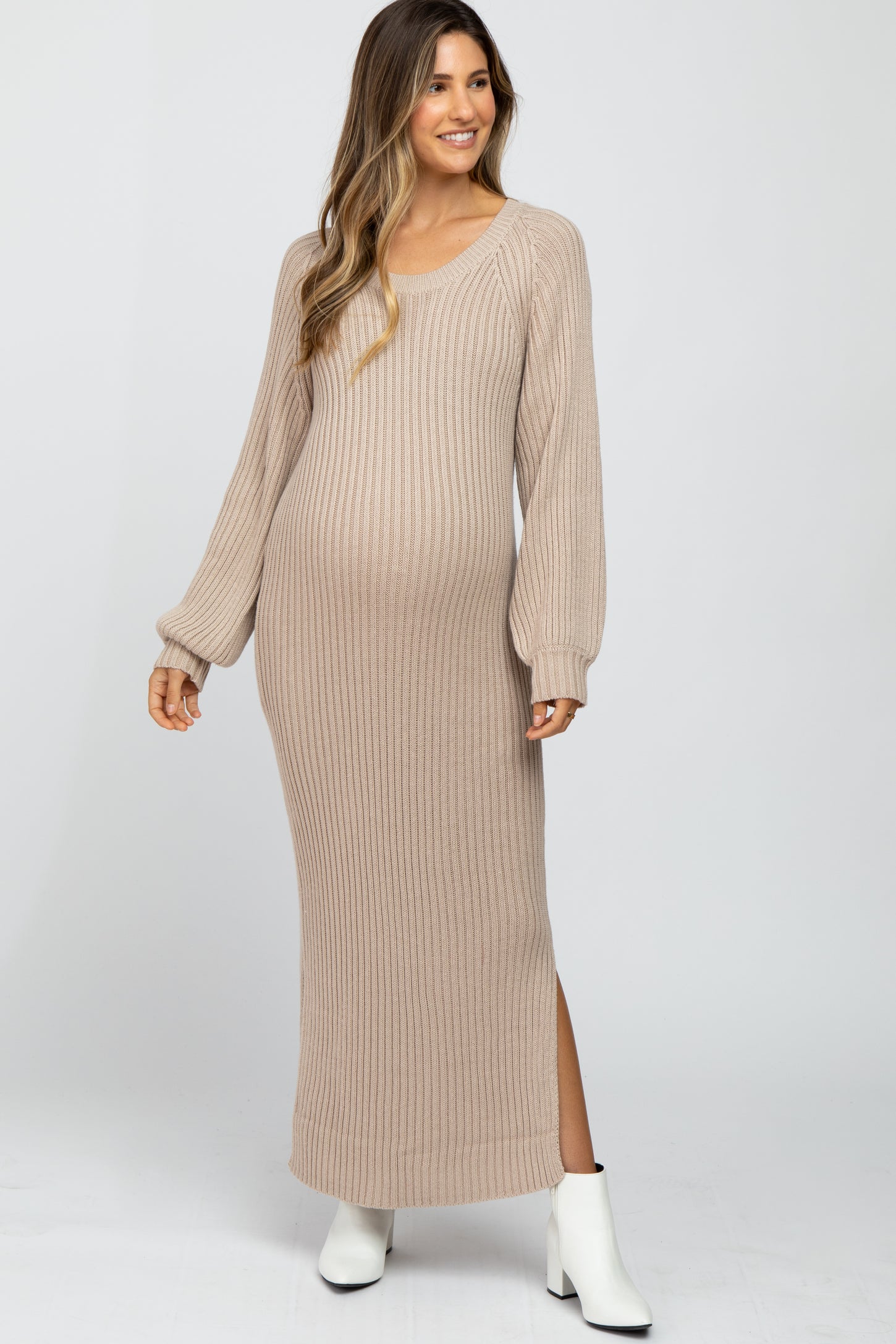 woman wearing a light beige ribbed maternity maxi dress with long sleeves and side slits, showing her baby bump
